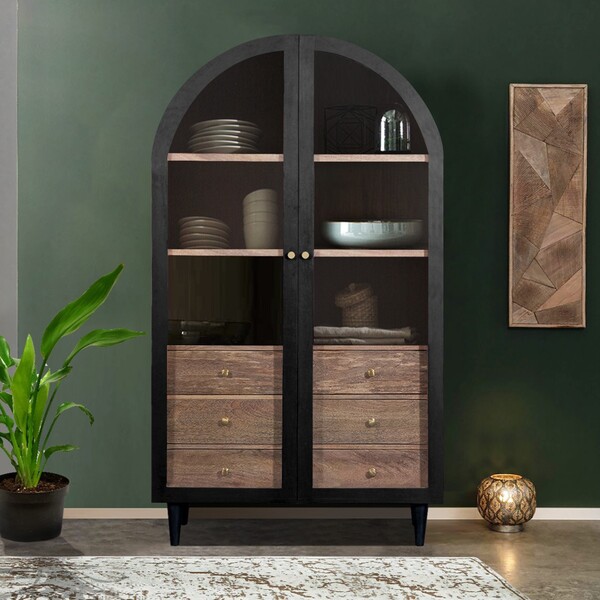 Tall arched glass display cabinet in dark wood against a deep green wall